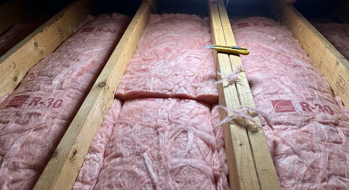 Fiberglass batt insulation precisely installed between attic joists
