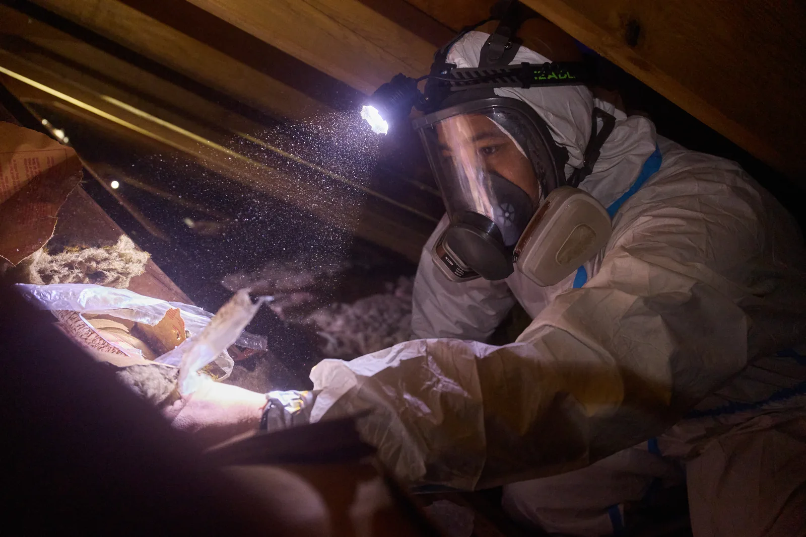 Attic cleanup technician documenting dusty attic contamination